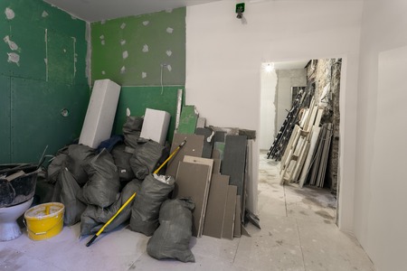 Construction garbage in the room with plasterboard or drywall in the bags are an apartment during on...
