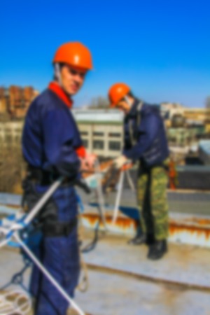 Blurred professional industrial climbers in helmet and uniform works at height for instaling...