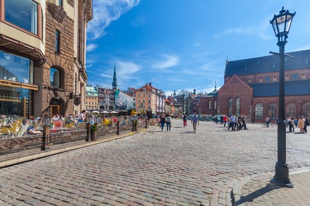 RIGA, LATVIA - MAY 06, 2017: View on the  colored cozy  old houses, churches and Dome Square with street cafes that are  located in the city center of Riga.のeditorial素材