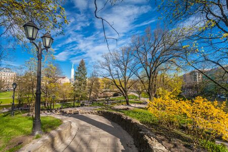 RIGA, LATVIA - MAY 06, 2017: View on  pathways with blossom trees, bushes and walking  people in The Park Bastion Hill that is located in the city center of Riga. Bastion Hill is one of the most romantic places in central Rigaのeditorial素材
