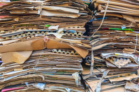 Stack of cartons and paper waiting to be picked up by the garbage trucks. Concept of recycling of waste paper or wastepaper.の写真素材