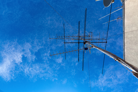 TV antennas are on the roof and blue sky as a backgroundの写真素材