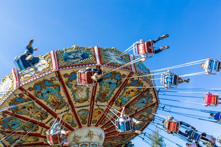 Russia, Saint Petersburg - August 31, 2019: Divo Ostrov amusement park. Carousel with cheerful children and adults. Motion effectのeditorial素材
