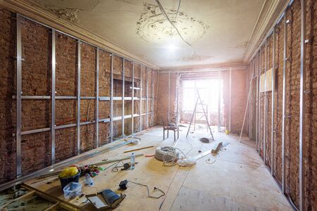Construction materials, tools and installed rames for plasterboard for making gypsum walls on the brick wall in in apartment that is under construction, remodeling, renovation, overhaul, extension, restoration and reconstruction. Concept of home improvementの写真素材