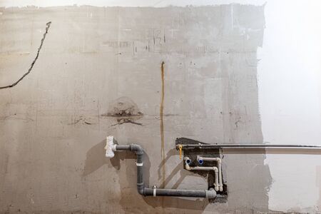 Plastic tubes of plumbing and canalization in apartment that is under construction, remodeling, renovation, overhaul, extension, restoration and reconstruction. Concept of total home improvement.の写真素材