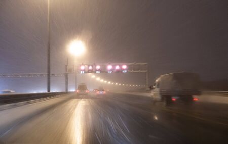 Image with motion blurred effect.Cars fast drive on the winter speedway or highway with roadway...