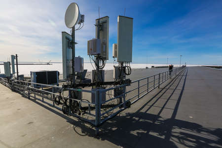 Russia, Saint-Petersburg - March 29, 2019: Telecommunication radio panel antennas, outdoor remote radio units and cables of Base Transceiver Station (BTS) are installed on top of a building. Outside part 5G, 4G, 3G, 2G basic station.のeditorial素材