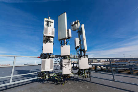 Russia, Saint-Petersburg - March 29, 2019: Telecommunication radio panel antennas, outdoor remote radio units and cables of Base Transceiver Station (BTS) are installed on top of a building. Outside part 5G, 4G, 3G, 2G basic station.のeditorial素材