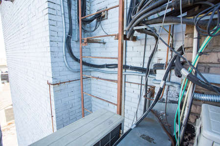 Russia, Saint-Petersburg - April 30, 2018: Cables are near of climatic vandal-proof cabinet with microwave equipment and power cables, coaxial cables, optic fibers. Typical basic station of telecommunication operators.のeditorial素材
