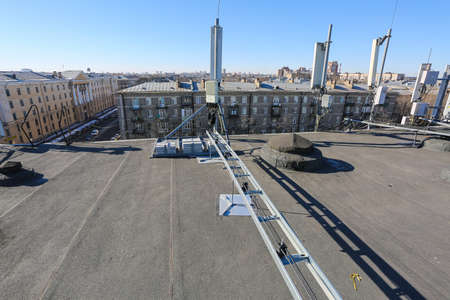Russia, Saint-Petersburg - April 30, 2018: Metal ladder trays with power, data, optic and ground cables of Base Transceiver Station (BTS) are installed on top of a building. Outside part 5G, 4G, 3G, 2G basic stationのeditorial素材