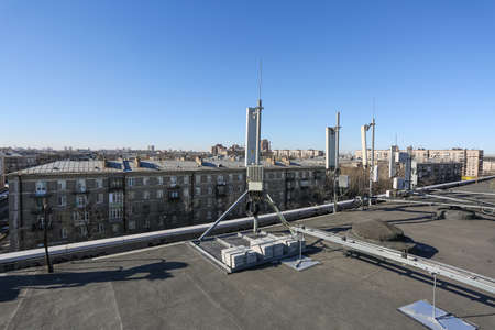 Russia, Saint-Petersburg - April 30, 2018: Panel antenna of 5G, 4G, 3G, 2G bands, optical fibers, power cables and outdoor remote radio units are as part of communication equipment of basic telecommunication station are installed on the roof. Outside partのeditorial素材