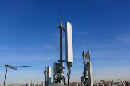 Russia, Saint-Petersburg - April 30, 2018: Panel antenna of 5G, 4G, 3G, 2G bands, optical fibers, power cables and outdoor remote radio units are as part of communication equipment of basic telecommunication station are installed on the roof. Outside partのeditorial素材