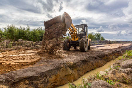 Road Construction and one of the construction machinery - bulldozer is flattenings the sand on the road before asphalting.の写真素材