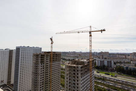 Large construction site including several cranes working on a building complex, workers,...