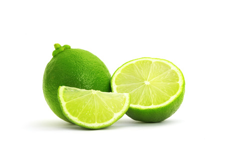 Limes with slices isolated on white backgroundの写真素材