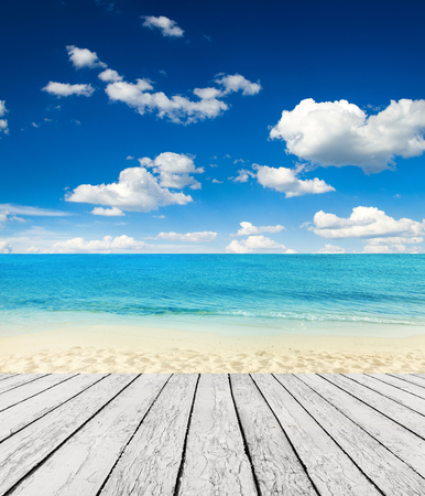 Empty wooden pier beside tropical beachの写真素材