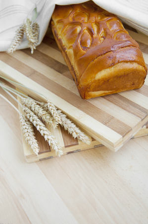 Bread stuffed with apple and wheat on wooden backgroundの写真素材