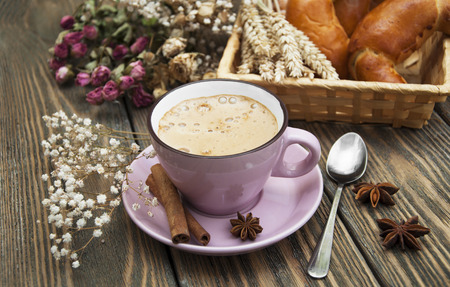 Coffee cup with buns in a basket on dark in wooden tableの写真素材