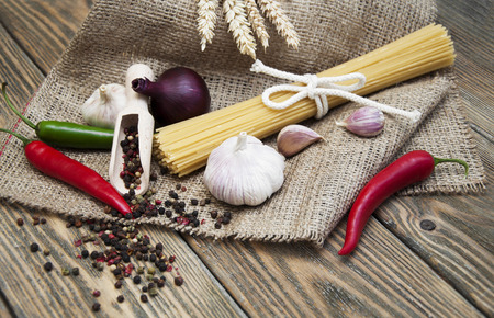 Traditional ingredients for seasoning of a good plate of pasta on a wooden backgroundの写真素材