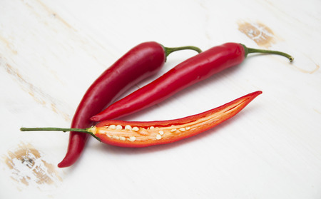 Red chili peppers on the white wooden backgroundの写真素材