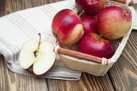 Ripe sweet apples in basket on wooden backgroundの写真素材
