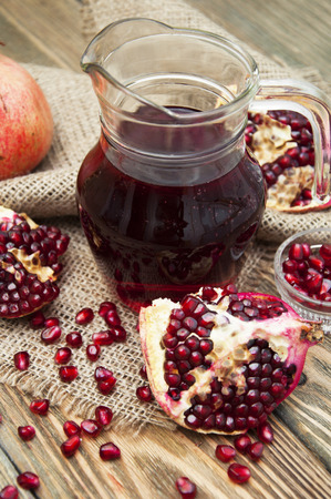 Pomegranate juice in a jug on a wooden backgroundの写真素材