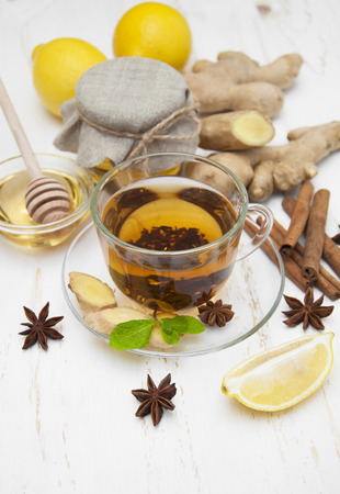 A cup of tea with fresh honey, lemon, ginge and spices on wooden backgroundの写真素材