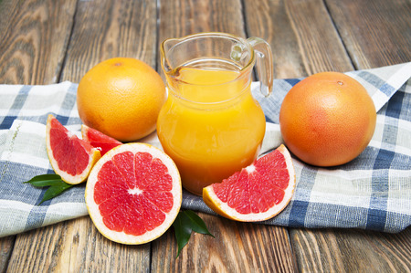 Grapefruit juice and grapefruit on wooden backgroundの写真素材