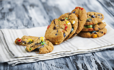 Bright, colorful oatmeal cookies on a napkin on a wooden backgroundの写真素材