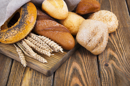 Different bread and wheat on the wooden tableの写真素材