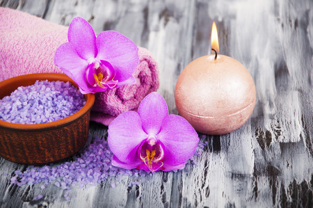 Spa composition with  spa accessories, orchid flowers and towels on a wooden backgroundの写真素材
