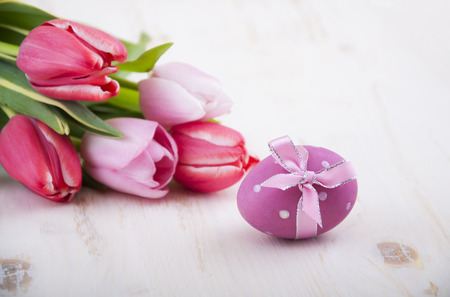 Beautiful pink tulips and Easter eggs on a wooden backgroundの写真素材