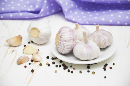 Garlic on a plate on wooden backgroundの写真素材