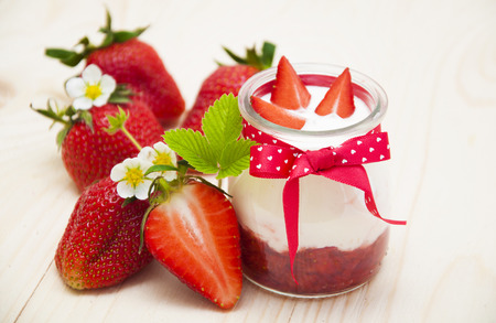 Strawberry yogurt with fresh strawberries on a wooden backgroundの写真素材