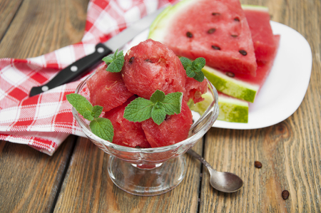Watermelon balls with mint in a bowl on a wooden backgroundの写真素材