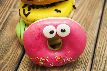 Colorful delicious donuts on a wooden backgroundの写真素材