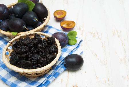 Prunes with fresh plums on a wooden backgroundの写真素材