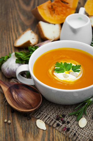 Pumpkin soup puree with spices on a wooden tableの写真素材
