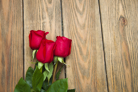 Beautiful red roses on a wooden backgroundの写真素材