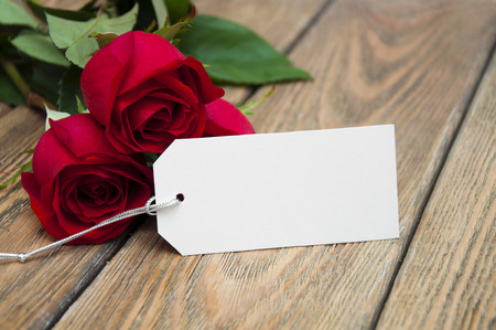Greting cart with red roses on a wooden background.の写真素材