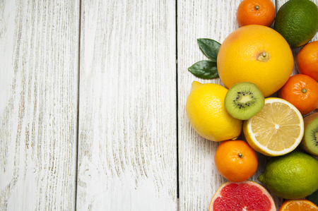 Fresh juicy citrus fruits on a white wooden backgroundの写真素材