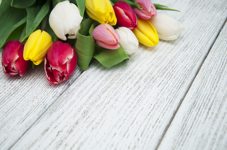 Bouquet of colorful tulips on a wooden boardの写真素材