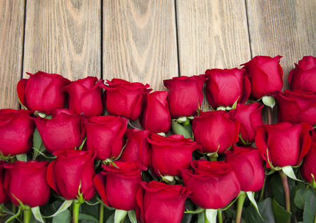 Beautiful red roses on a wooden backgroundの写真素材