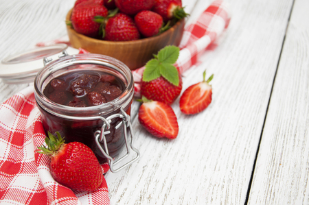 Strawberry jam with fresh strawberries on a wooden tableの写真素材