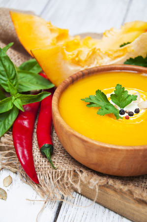 Bowl of pumpkin soup on rustic wooden backgroundの写真素材