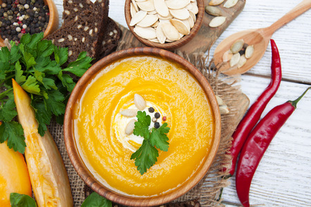 Bowl of pumpkin soup on rustic wooden backgroundの写真素材