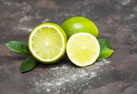 Fresh juicy limes on a stone backgroundの写真素材