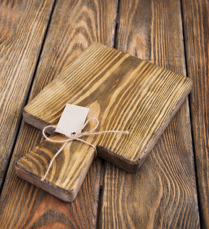Wooden cutting board on a wooden backgroundの写真素材