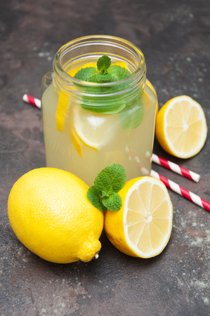 Homemade lemonade with fresh lemon and mint on a stone backgroundの写真素材