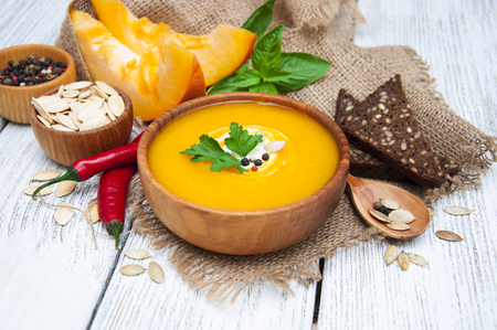 Bowl of pumpkin soup on rustic wooden backgroundの写真素材